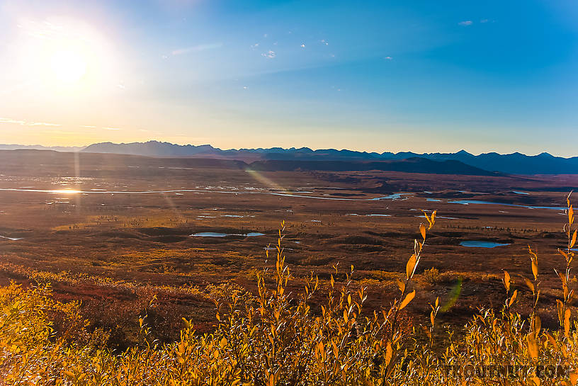 View west across the Maclaren River valley from Maclaren Summit. The Clearwater Mountains make up the highest part of the horizon near the sun. From Denali Highway in Alaska.