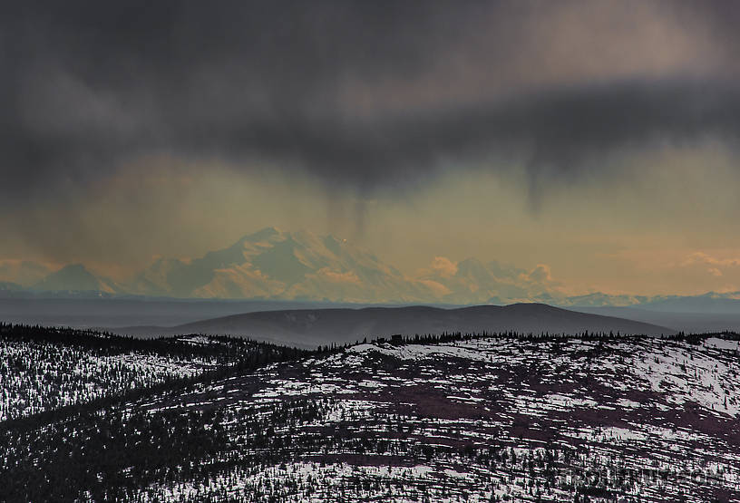 Denali from near Murphy Dome. I don't know what the peculiar bright light is shining near the top of the mountain on the right side. It was conspicuous like this for several minutes. I don't know what's up there that would reflect sunlight (or emit its own light) and look so much brighter than everything else from 150 miles away. From Murphy Dome in Alaska.