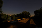 The moon lights a bridge under the stars near midnight over a nice trout river. From the Namekagon River in Wisconsin.