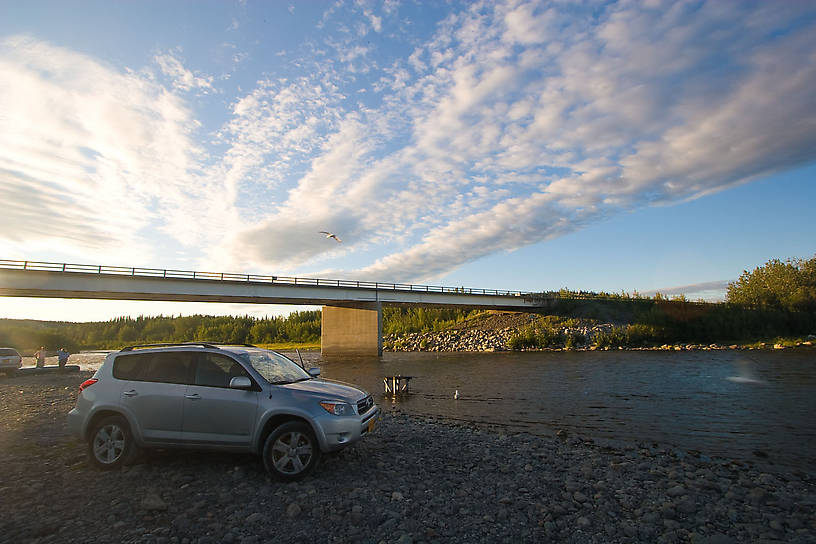 There's a fish-cleaning table right IN the river at this landing.  Driving out on the gravel bar is the norm, too.  It was a good place to field-dress my sockeye salmon.  Tossing the guts out into the river has them devoured by hungry gulls within seconds.  That's illegal in many places, but in Alaska it's the preferred way of dealing with fish waste: these ecosystems are driven by dead salmon and fully equipped to deal with it. From the Gulkana River in Alaska.